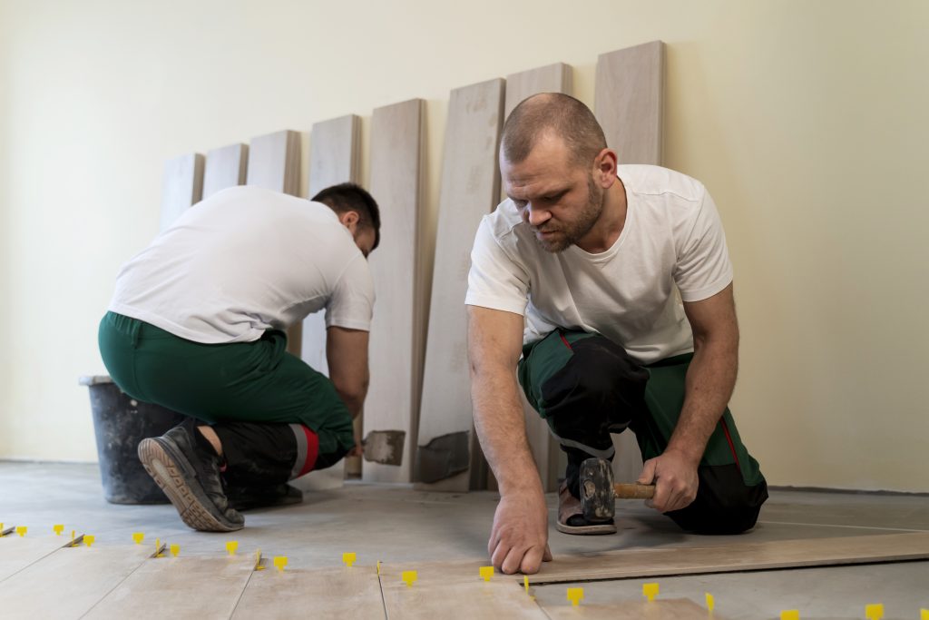 full shot workers tiling floor indoors